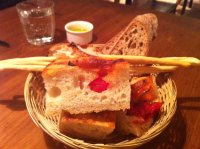 Tomato-studded foccacia with olive oil for dipping and homemade grissini.