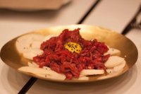 raw beef and egg yolk served with slices of pear