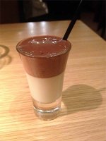 Shot glass with warm dark chocolate at the top and cold white chocolate cream at the bottom